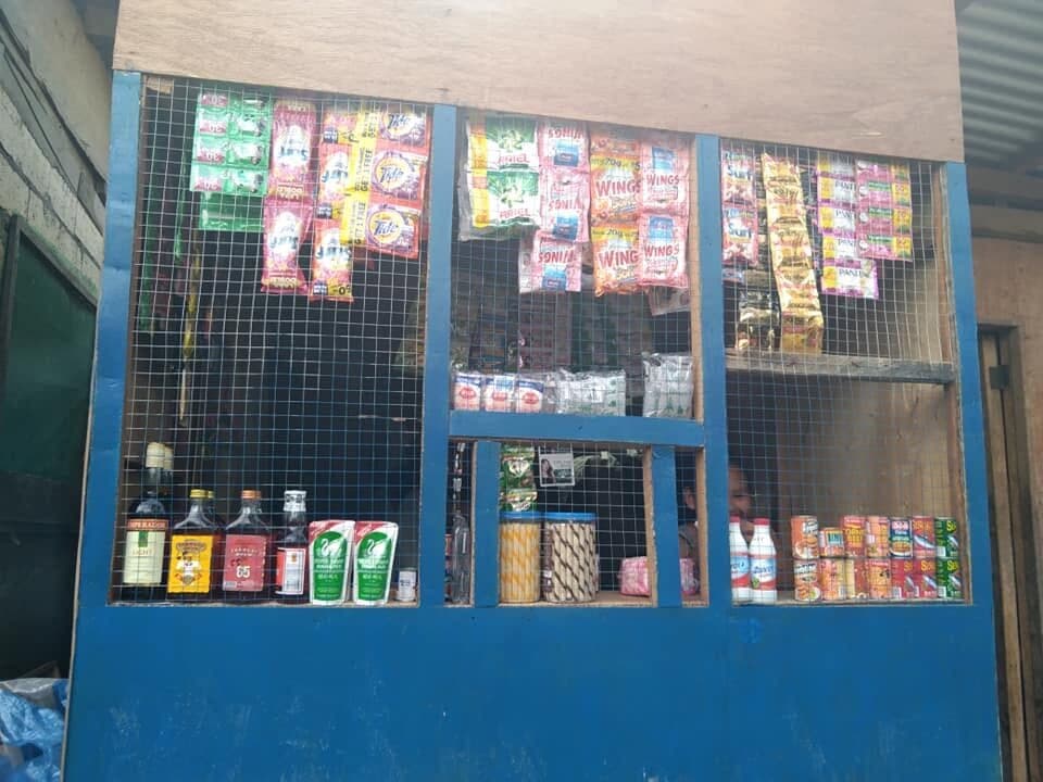 The community shop: a small blue kiosk hung with snacks, drinks and daily goods.